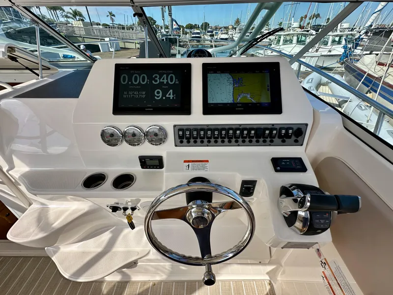 Slide: The Image of 2018 Wellcraft 290 Coastal helm with dual displays, gauges, and controls in a marina setting. - 22