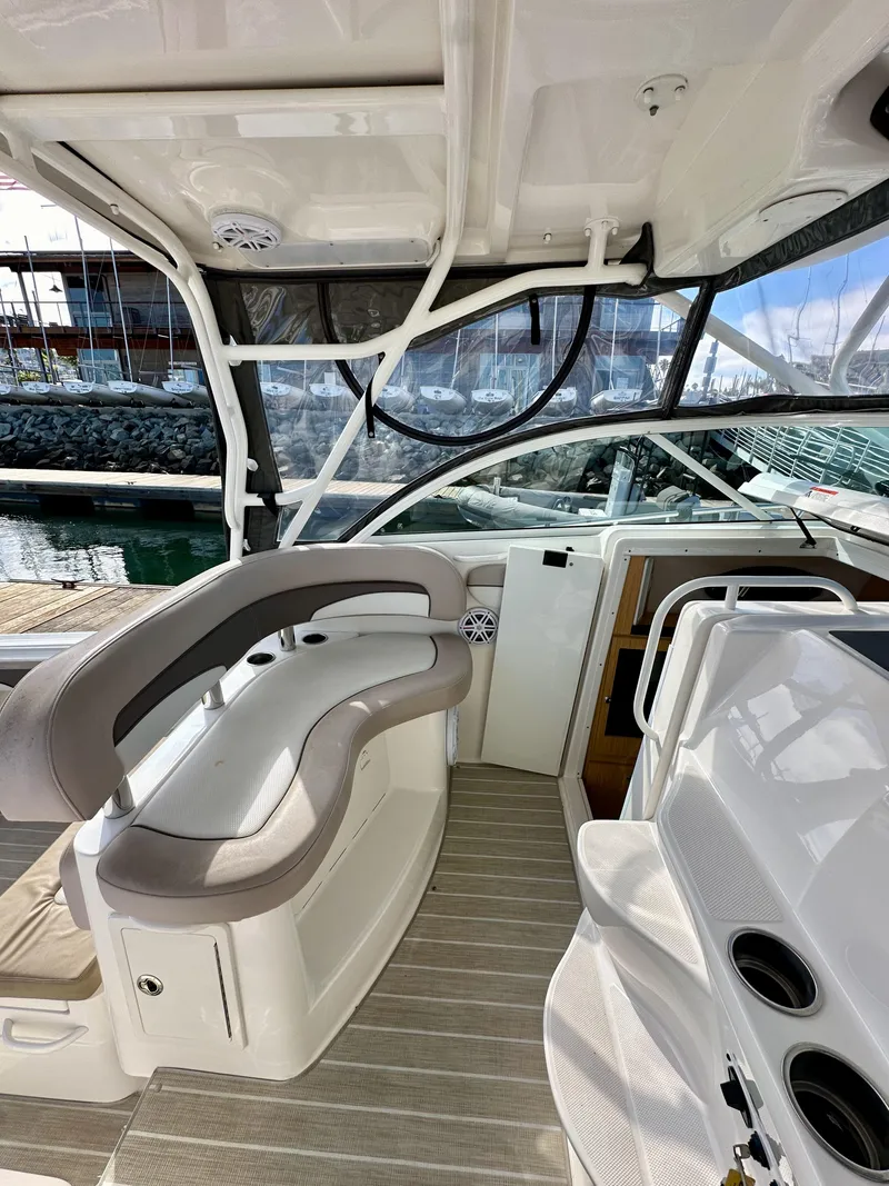 Slide: The Image of 2018 Wellcraft 290 Coastal boat interior with seating and helm, docked at marina. - 23