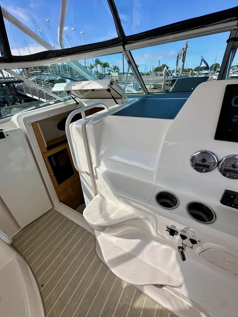 Slide: The Image of 2018 Wellcraft 290 Coastal boat interior with helm, gauges, and cabin entrance. - 24