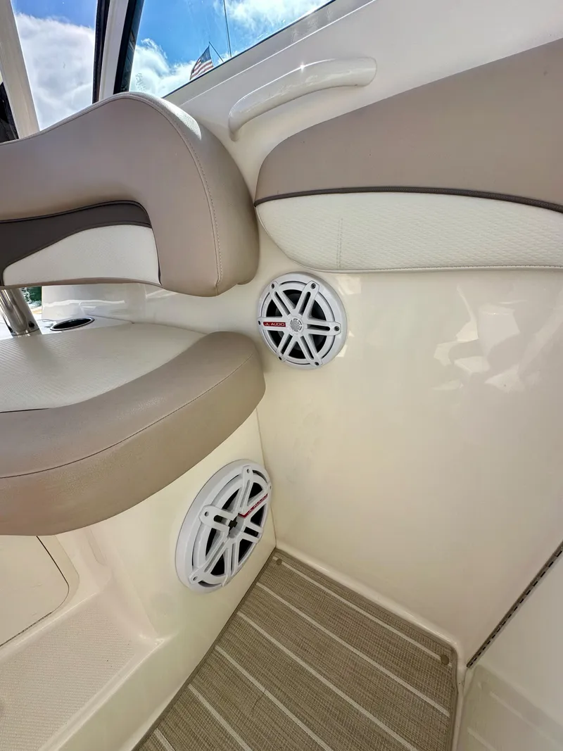 Slide: The Image of Interior of 2018 Wellcraft 290 Coastal boat with beige seating and built-in speakers. - 25
