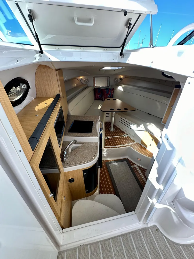 Slide: The Image of 2018 Wellcraft 290 Coastal cabin interior with kitchenette, seating, and wooden flooring. - 26