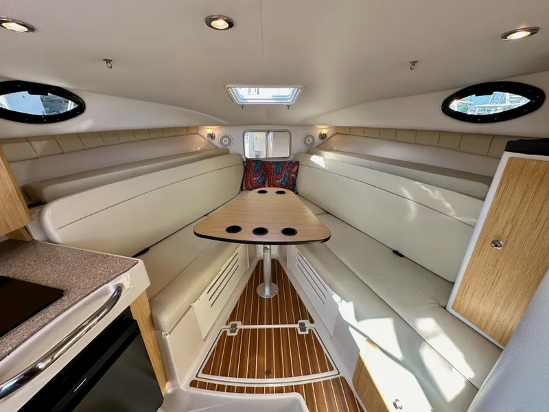 Slide: The Image of 2018 Wellcraft 290 Coastal cabin interior with seating, table, and wood accents. - 29