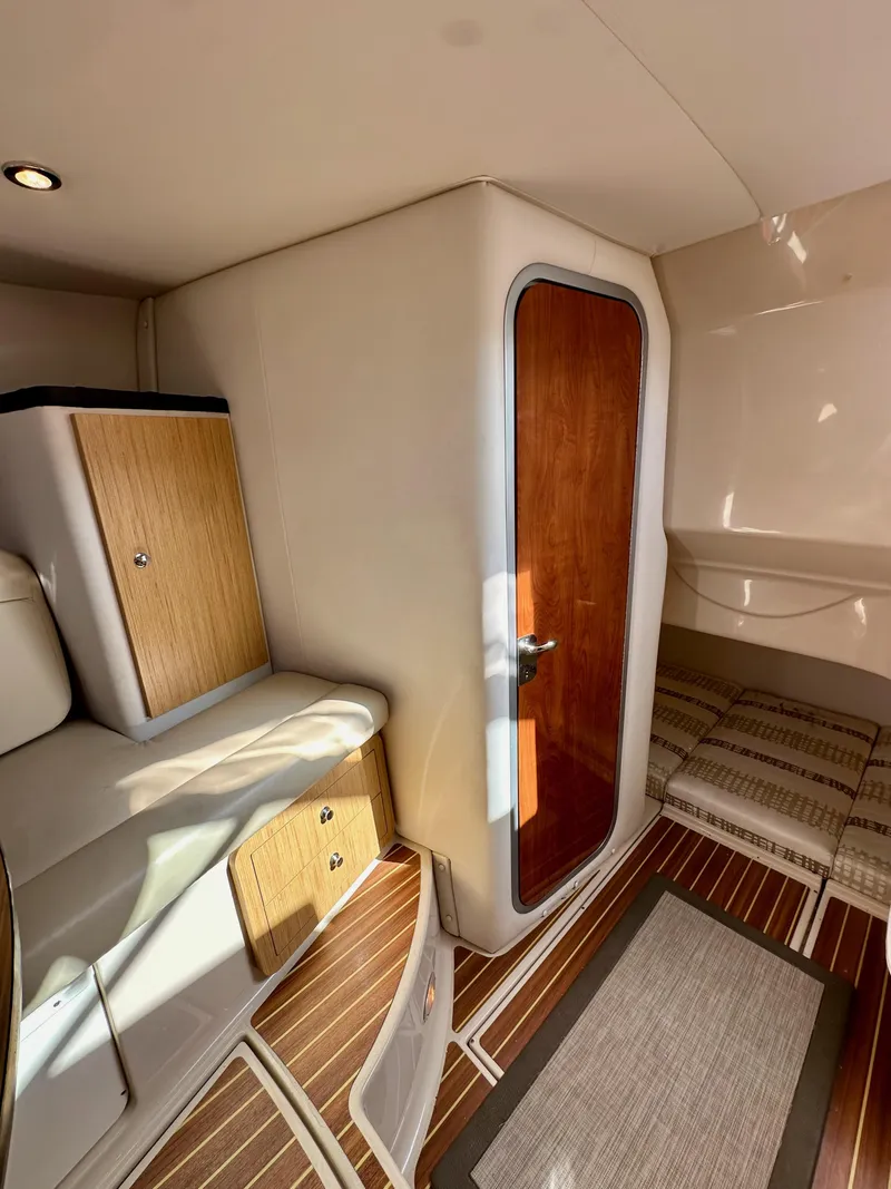 Slide: The Image of 2018 Wellcraft 290 Coastal cabin interior with wood accents and cozy seating. - 34