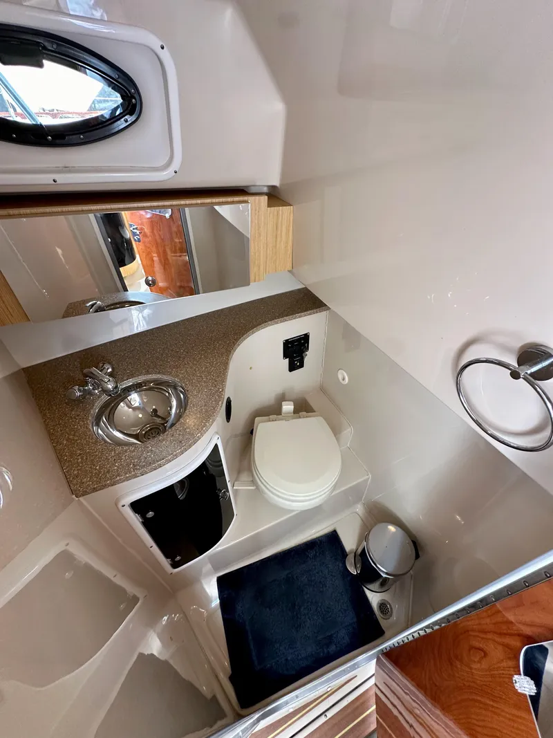 Slide: The Image of 2018 Wellcraft 290 Coastal bathroom with sink, toilet, and mirror. - 35