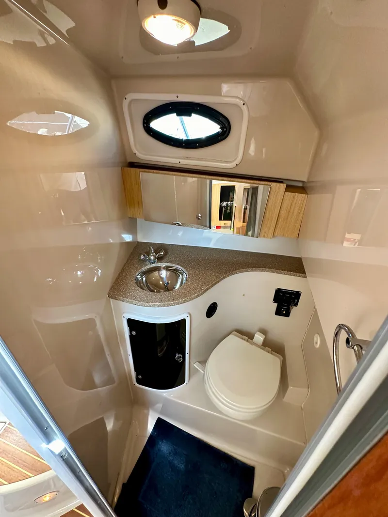 Slide: The Image of 2018 Wellcraft 290 Coastal boat bathroom with sink, toilet, and mirror. - 36