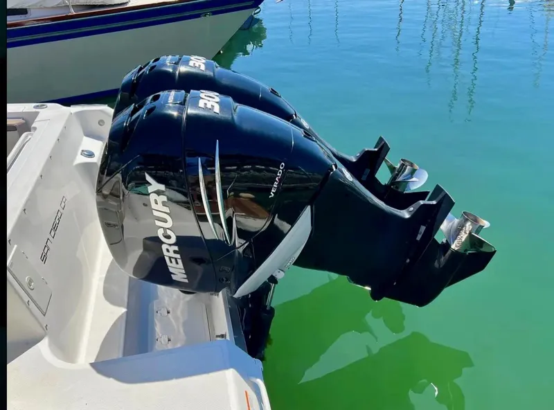 Slide: The Image of 2018 Wellcraft 290 Coastal boat with twin Mercury outboard engines in a marina setting. - 43