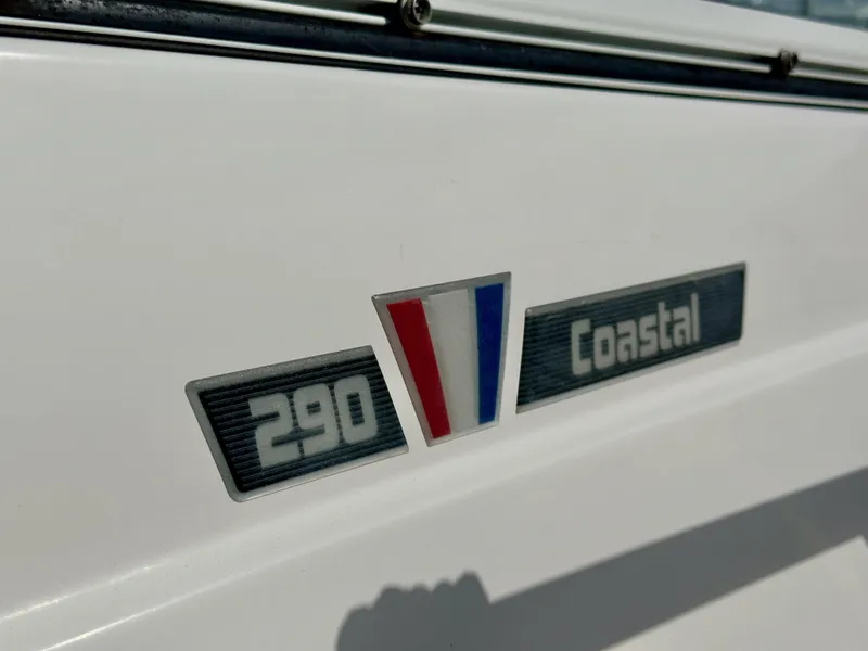 Slide: The Image of 2018 Wellcraft 290 Coastal boat emblem with red, white, and blue design. - 6