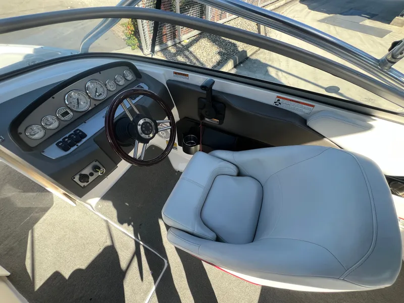 Slide: The Image of 2007 Regal 2000 boat cockpit with steering wheel and gauges, featuring a comfortable captain's chair. - 14