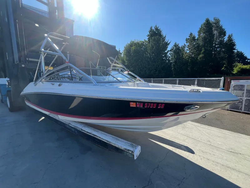 Slide: The Image of 2007 Regal 2000 boat on trailer, parked outdoors under clear blue sky. - 4