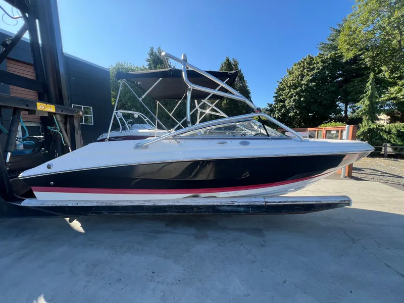 Slide: The Image of 2007 Regal 2000 boat with canopy on a lift, surrounded by trees and buildings. - 5