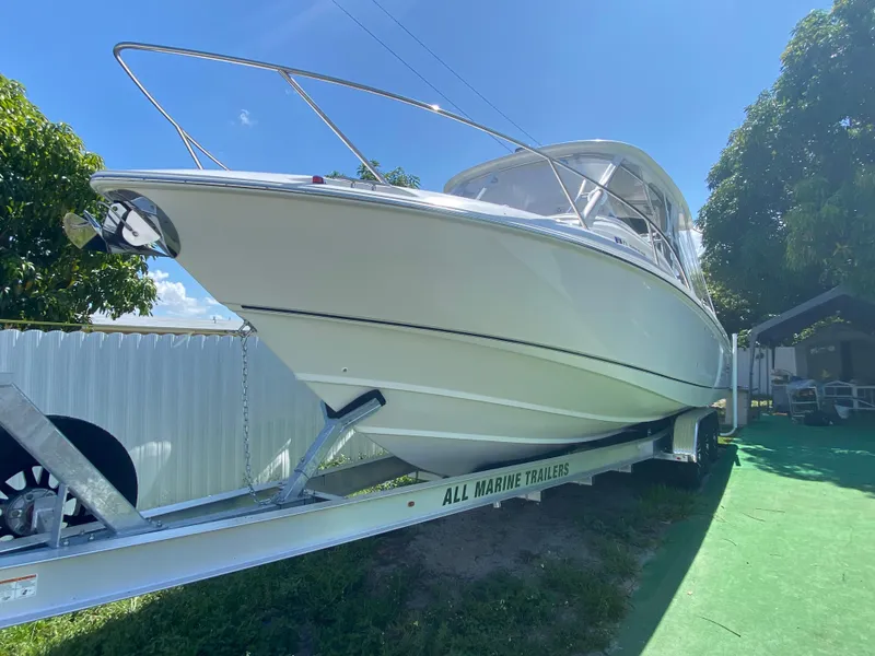 Slide: The Image of 2007 Boston Whaler 320 Outrage Cuddy Cabin on trailer, sunny day, green grass. - 11