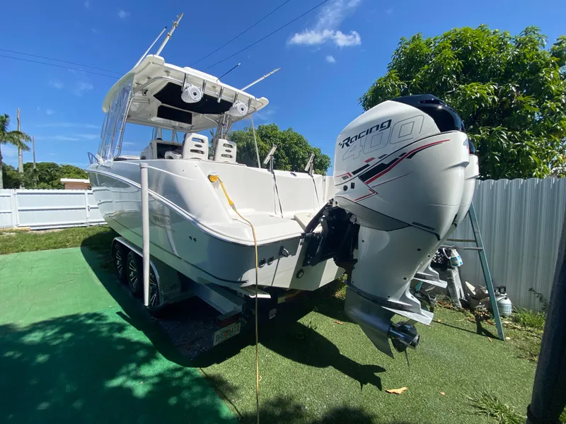 Slide: The Image of 2007 Boston Whaler 320 Outrage Cuddy Cabin with powerful outboard engine, parked outdoors. - 27