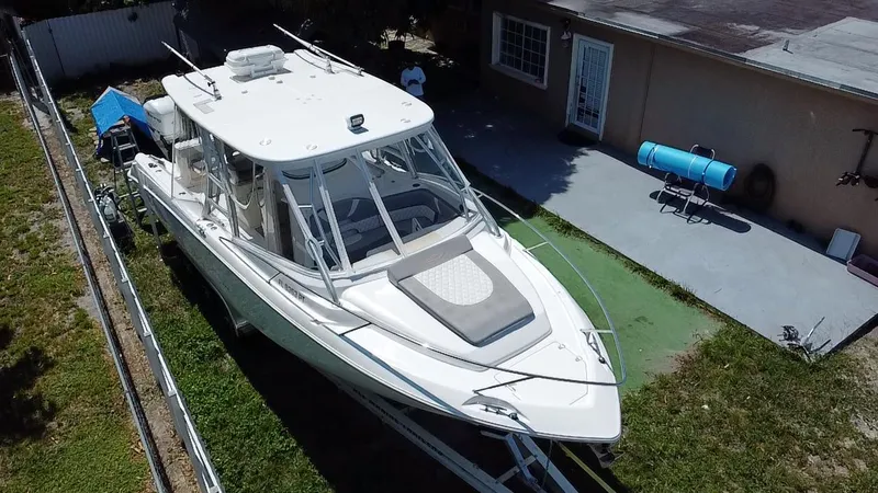 Slide: The Image of 2007 Boston Whaler 320 Outrage Cuddy Cabin boat parked beside a house. - 9