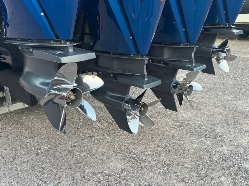 Slide: The Image of 2023 Fountain 38 SC boat propellers, shiny and metallic, on gravel surface. - 15