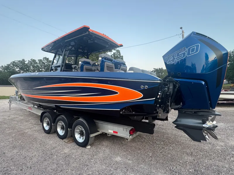 Slide: The Image of 2023 Fountain 38 SC boat with vibrant orange and blue design on a trailer. - 16