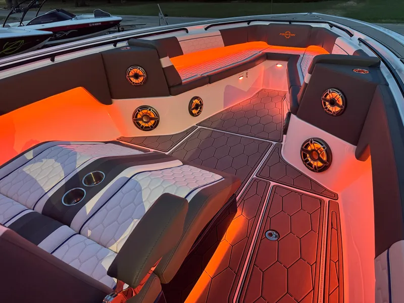 Slide: The Image of Luxurious 2023 Fountain 38 SC boat interior with ambient orange lighting and stylish seating. - 2