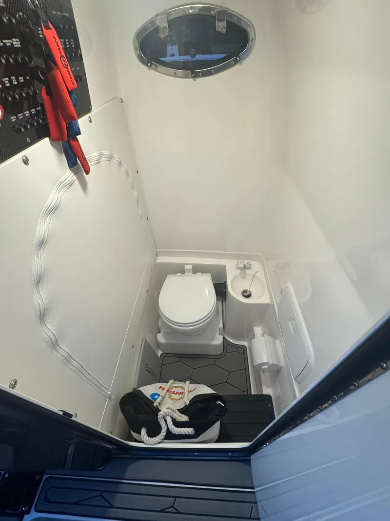 Slide: The Image of 2023 Fountain 38 SC boat bathroom with toilet, sink, and storage. - 23