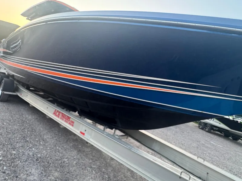 Slide: The Image of 2023 Fountain 38 SC boat on trailer, sleek design with blue and orange accents. - 5