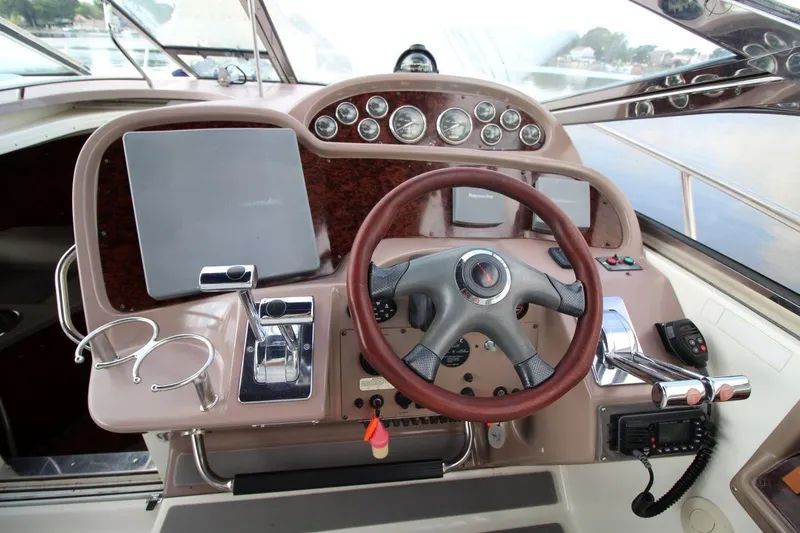 Slide: The Image of 2004 Regal Commodore 3860 boat helm with steering wheel, controls, and navigation equipment. - 12
