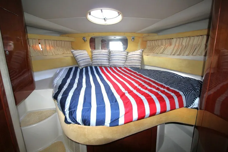 Slide: The Image of Cozy cabin interior of 2004 Regal Commodore 3860 with striped bedding and porthole. - 16