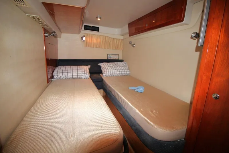 Slide: The Image of 2004 Regal Commodore 3860 cabin interior with twin beds and wooden cabinetry. - 17