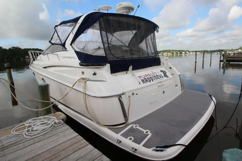 Slide: The Image of 2004 Regal Commodore 3860 yacht docked by a serene waterfront. - 4