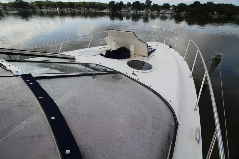 Slide: The Image of 2004 Regal Commodore 3860 yacht on calm water, showcasing sleek deck design. - 5