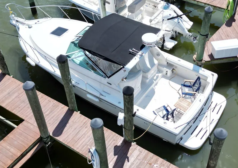 Slide: The Image of 2001 Tiara Yachts 2900 Open docked, featuring a spacious deck and black canopy. - 1