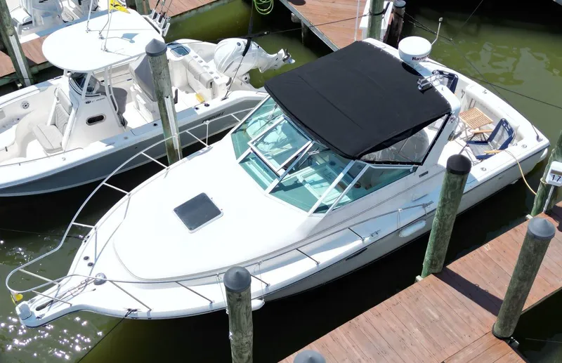 Slide: The Image of 2001 Tiara Yachts 2900 Open docked, featuring sleek design and black canopy. - 2