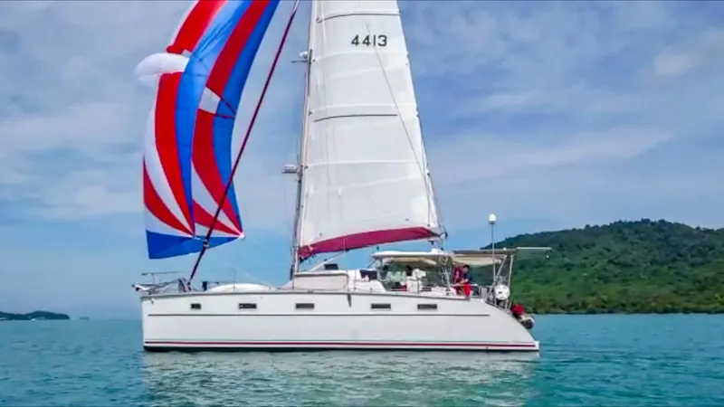 The Image of Sailing catamaran Antares PDQ 44, 2005 model, with colorful sails on open water. - 0