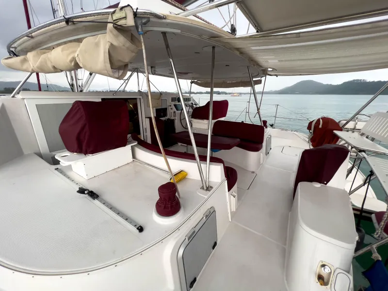 Slide: The Image of 2005 Antares PDQ 44 yacht deck with maroon seating, ocean view, and canopy. - 15