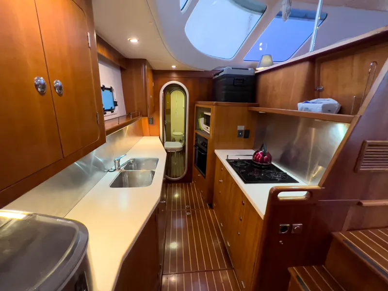 Slide: The Image of Luxurious 2005 Antares PDQ 44 yacht kitchen with wood cabinetry and modern appliances. - 30