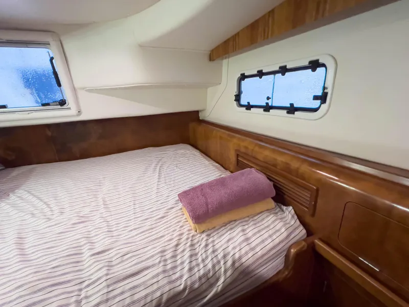 Slide: The Image of Cozy cabin interior of 2005 Antares PDQ 44 with striped bedding and porthole windows. - 31