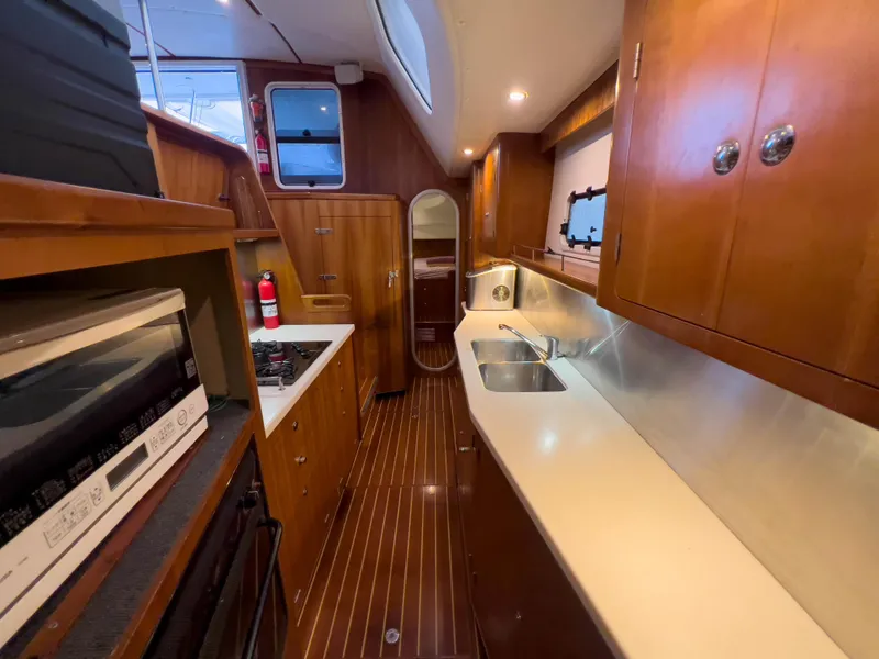 Slide: The Image of Luxurious 2005 Antares PDQ 44 yacht kitchen with wood cabinetry and modern appliances. - 39