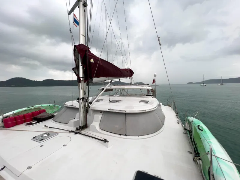 Slide: The Image of 2005 Antares PDQ 44 catamaran sailing on calm waters under cloudy skies. - 4
