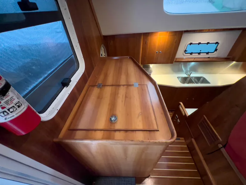 Slide: The Image of Interior of 2005 Antares PDQ 44 yacht with wooden cabinetry and compact kitchen area. - 44