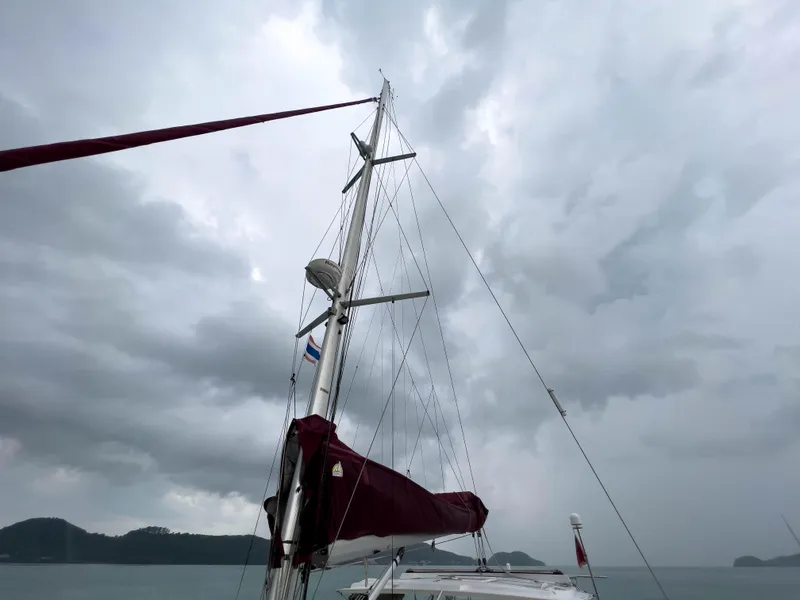 Slide: The Image of Sailboat mast of 2005 Antares PDQ 44 against cloudy sky, with distant hills. - 8