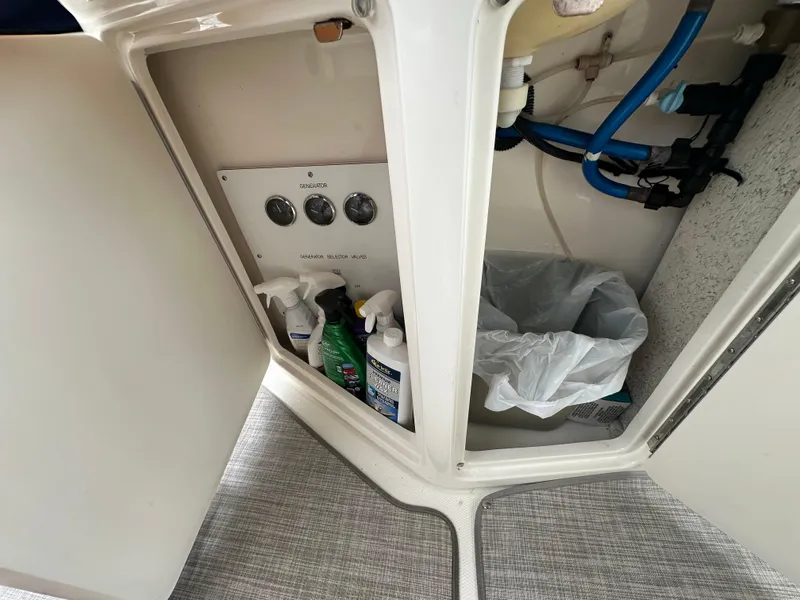 Slide: The Image of Open cabinet on 2003 Sea Ray 420 Sundancer with cleaning supplies and trash bin. - 13