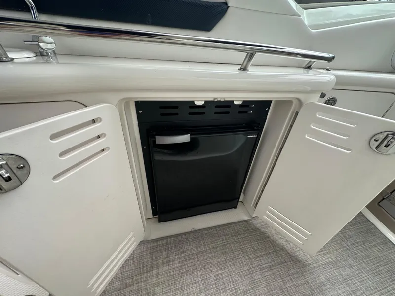 Slide: The Image of 2003 Sea Ray 420 Sundancer boat interior with open cabinet and mini fridge. - 14