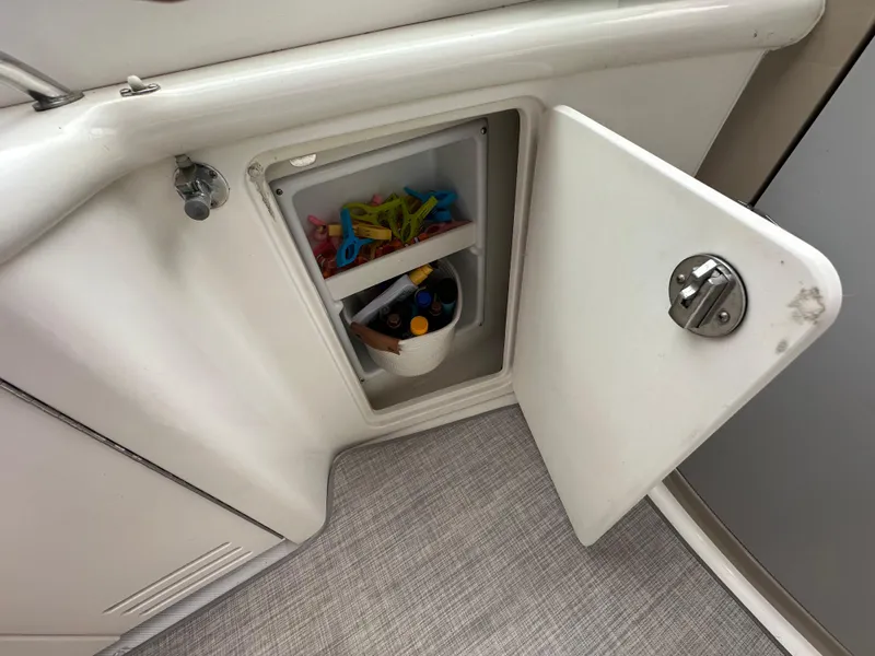 Slide: The Image of Open storage compartment on 2003 Sea Ray 420 Sundancer boat, containing various items. - 18