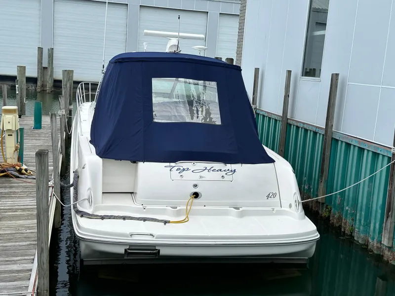 Slide: The Image of 2003 Sea Ray 420 Sundancer docked with blue cover, rear view. - 2