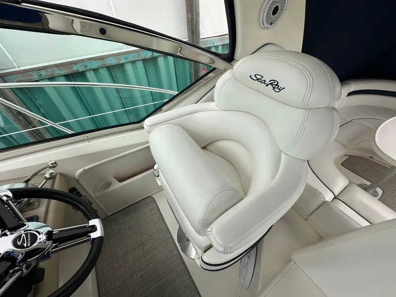 Slide: The Image of Captain's seat and helm of 2003 Sea Ray 420 Sundancer yacht, featuring luxurious white upholstery. - 22