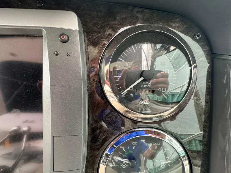 Slide: The Image of Dashboard of a 2003 Sea Ray 420 Sundancer showing RPM and speed gauges. - 23