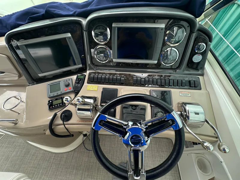 Slide: The Image of Dashboard of a 2003 Sea Ray 420 Sundancer with navigation screens and controls. - 25