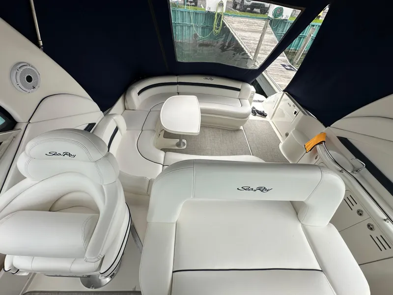 Slide: The Image of 2003 Sea Ray 420 Sundancer interior with white seating and table, featuring elegant design. - 29