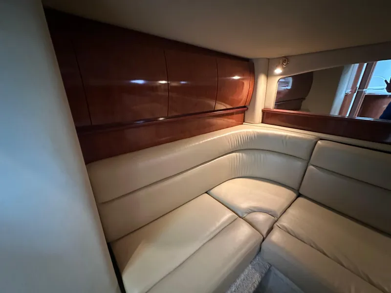 Slide: The Image of Luxurious interior of 2003 Sea Ray 420 Sundancer with beige leather seating and wooden accents. - 36