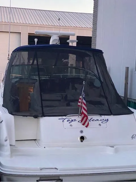 Slide: The Image of 2003 Sea Ray 420 Sundancer yacht docked with American flag displayed. - 4