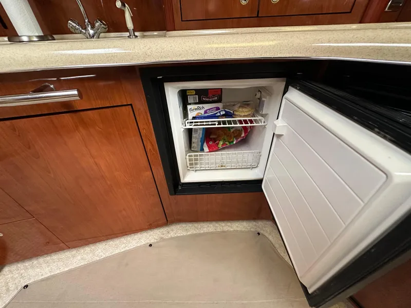 Slide: The Image of Open mini fridge in 2003 Sea Ray 420 Sundancer yacht kitchen, stocked with frozen foods. - 46