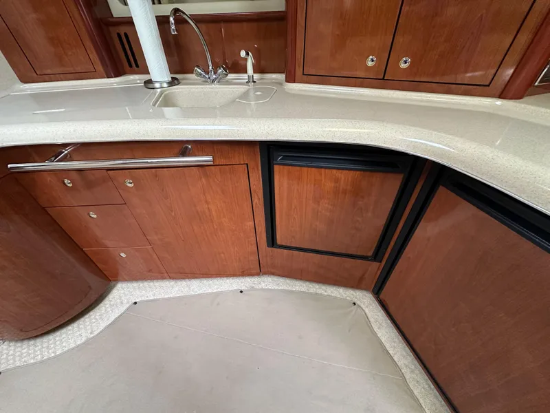 Slide: The Image of Luxurious kitchen area in 2003 Sea Ray 420 Sundancer yacht with wood cabinetry and sink. - 48