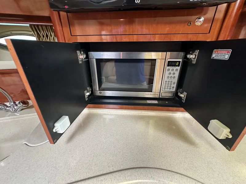 Slide: The Image of Microwave in 2003 Sea Ray 420 Sundancer yacht kitchen, with open cabinet doors. - 49